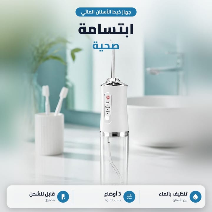 خيط مائي للاسنان لاسلكي على مغسلة الحمام جنب كوب فرش الأسنان